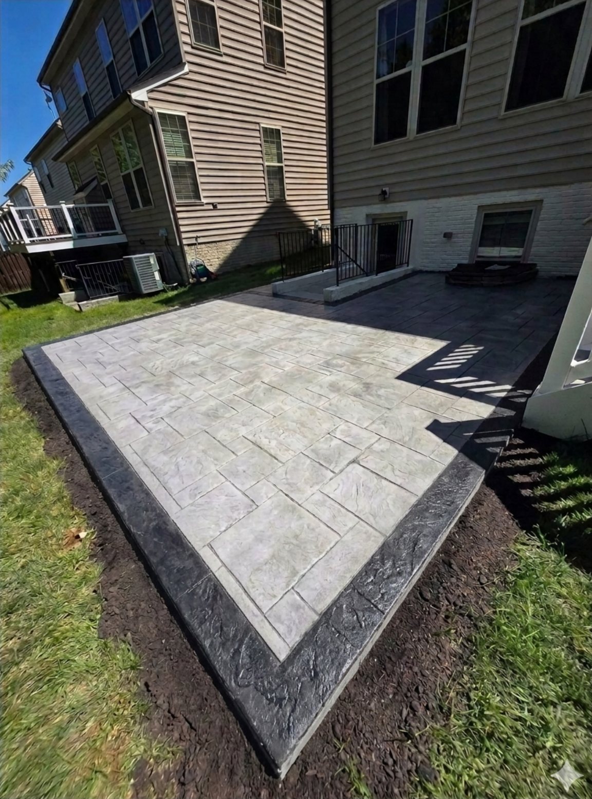 Stamped concrete patio in a slate pattern with a dark border