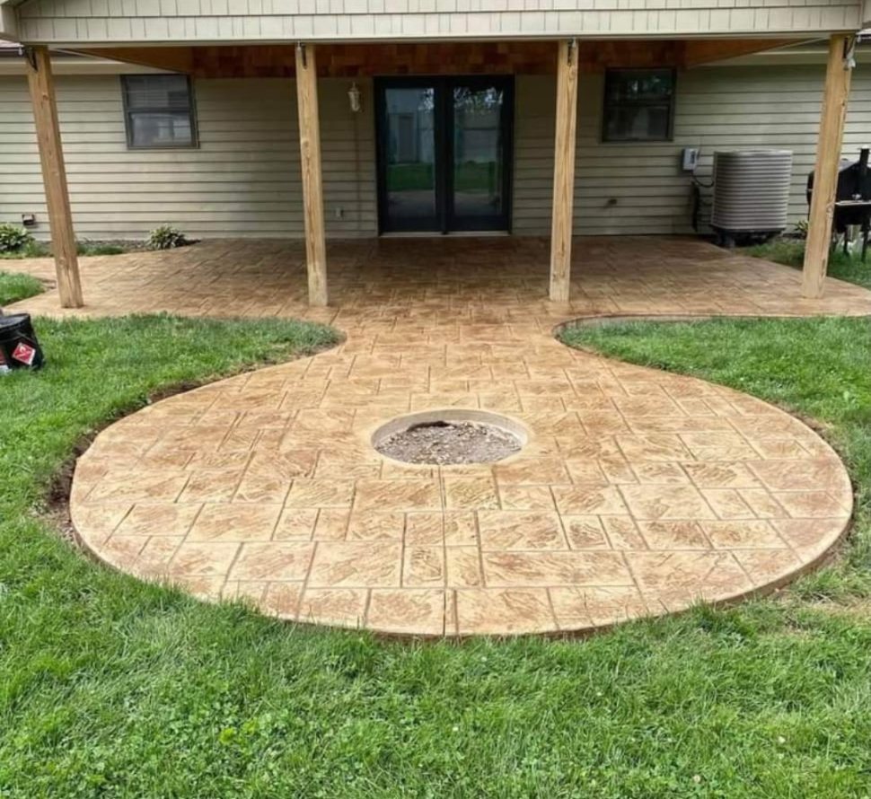 Round stamped concrete patio with a central fire ring extending from a covered porch