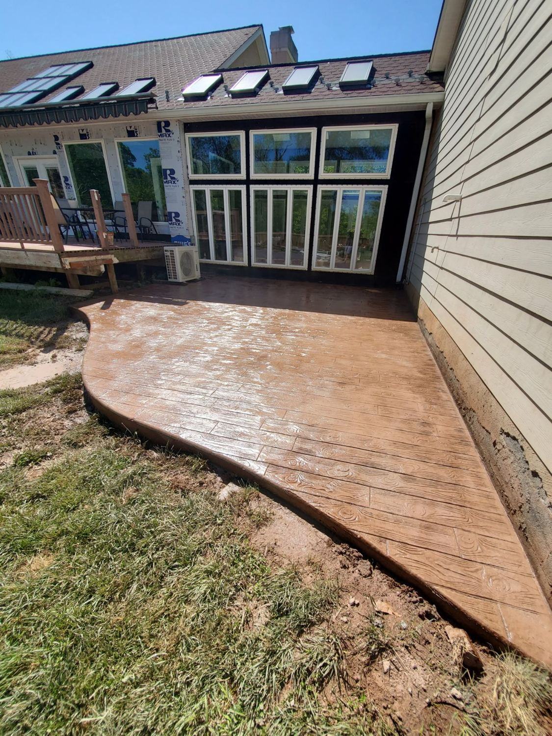 Stamped concrete patio in a wood-plank pattern with a curved edge