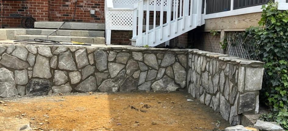 Mortared natural stone retaining wall turning a corner